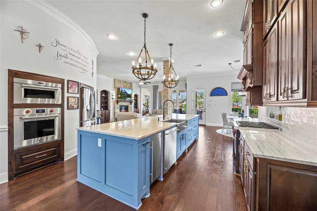 This luxurious chef's kitchen, remodeled in 2020, combines top-tier Wolf appliances, including both gas and electric ovens, with the elegance of a hand-crafted Rachiele Custom Copper Farm Sink and stunning granite and quartz countertops. Rich cabinetry and designer pendant lighting elevate the space, creating a sophisticated culinary sanctuary for those who appreciate the art of cooking in style.