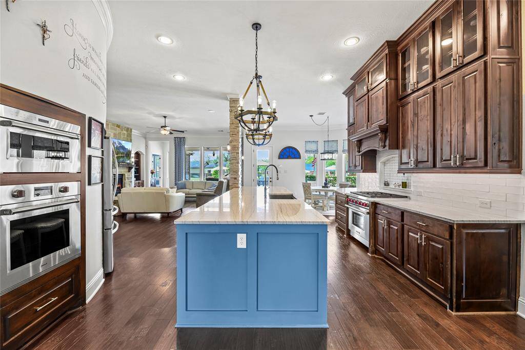 The opulent cabinetry, meticulously crafted with intricate detail, radiates timeless elegance, while the designer pendant lighting casts a warm, sophisticated glow, elevating the overall atmosphere of the space.