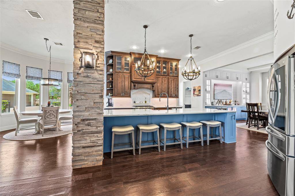 The expansive center island offers an abundance of space for effortless meal prep, while its integrated breakfast bar provides a perfect spot for casual dining or gathering, seamlessly blending functionality with luxury.