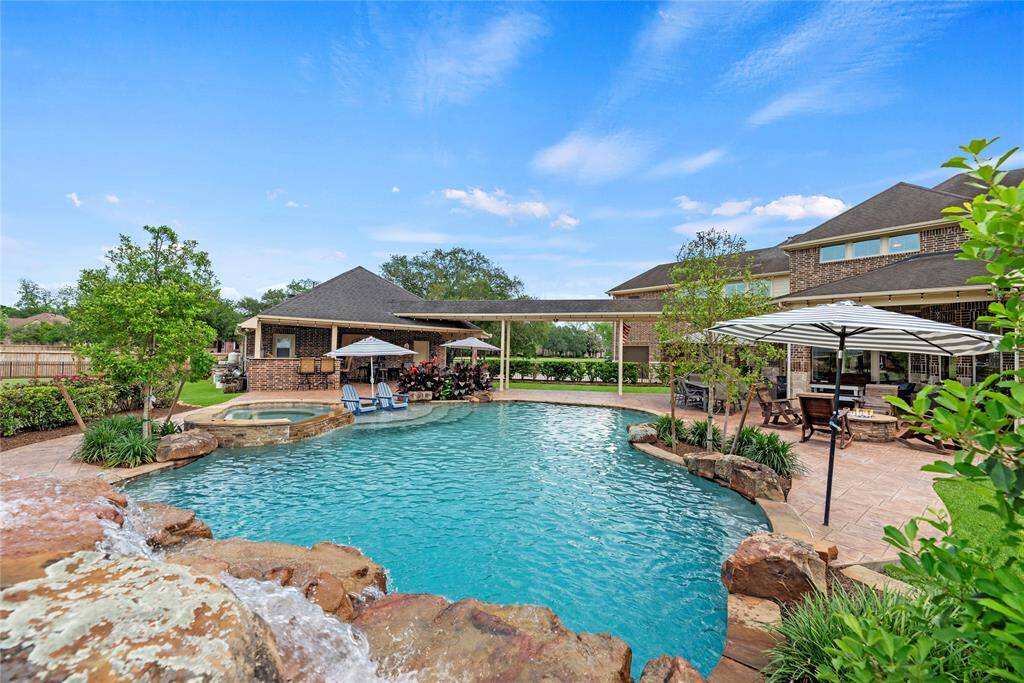 Indulge in your own private resort-style sanctuary featuring a stunning pool and spa with graceful water features, a sun-drenched tanning ledge, and cutting-edge remote control technology—all designed for effortless luxury and elevated outdoor living.