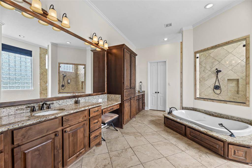 The custom-designed primary ensuite bath is a sanctuary of luxury, featuring separate sinks and vanities for ultimate convenience, abundant personal storage, a deep soaking tub for spa-like relaxation, and a lavish walk-in shower with premium finishes, all thoughtfully curated for comfort and elegance.