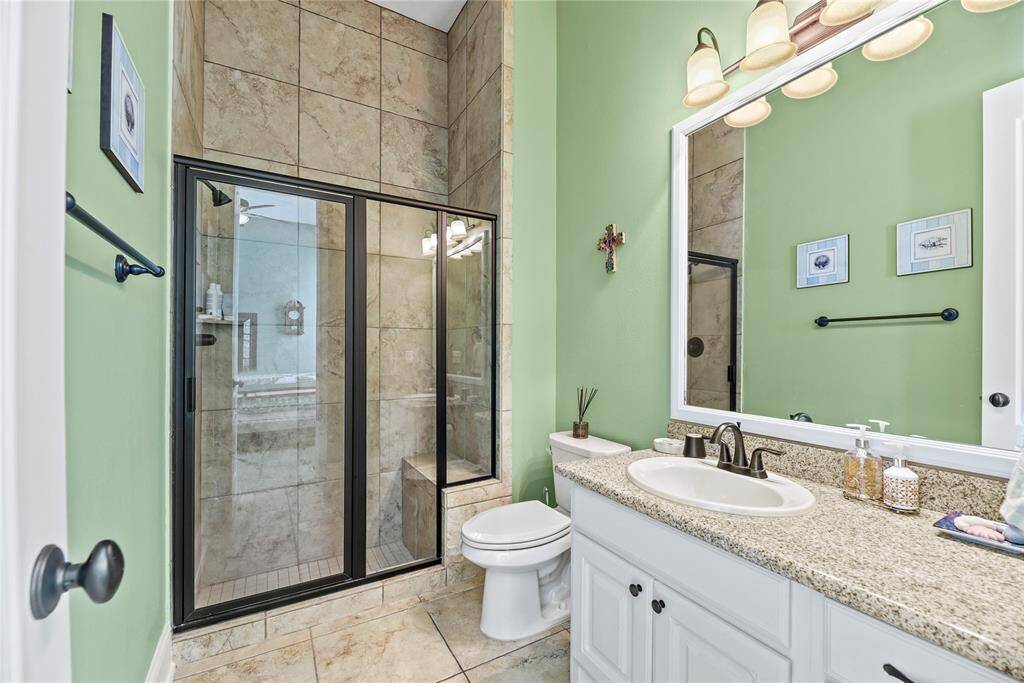 The secondary ensuite bath is a refined haven, featuring a spacious walk-in shower and a large, elegant vanity, designed to offer both functionality and luxury in a tranquil setting.