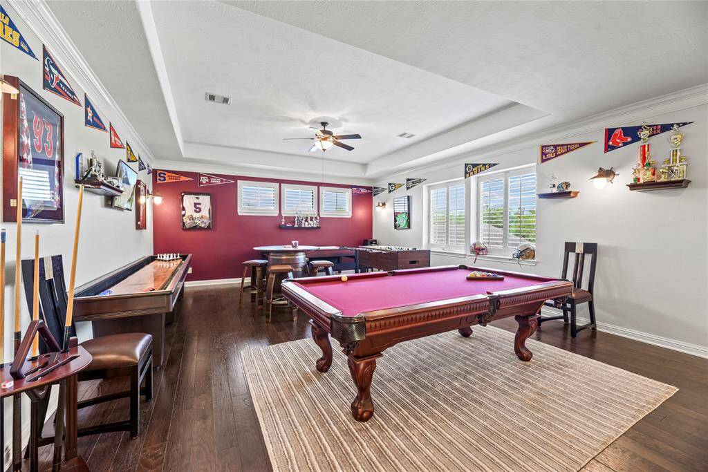 Welcome to the game room, a sophisticated entertainment haven spacious enough to accommodate a pool table, air hockey and foosball table, all under a stunning coffered ceiling that adds a touch of architectural elegance to this lively, luxurious space.