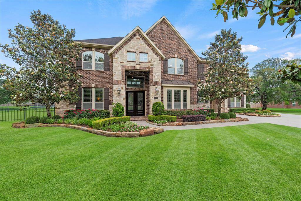 Welcome to 33210 W Calder Court, an exquisite home exuding timeless elegance with its masterfully crafted stone and brick façade, impeccably manicured grounds, and stately mature trees that frame a truly luxurious first impression.