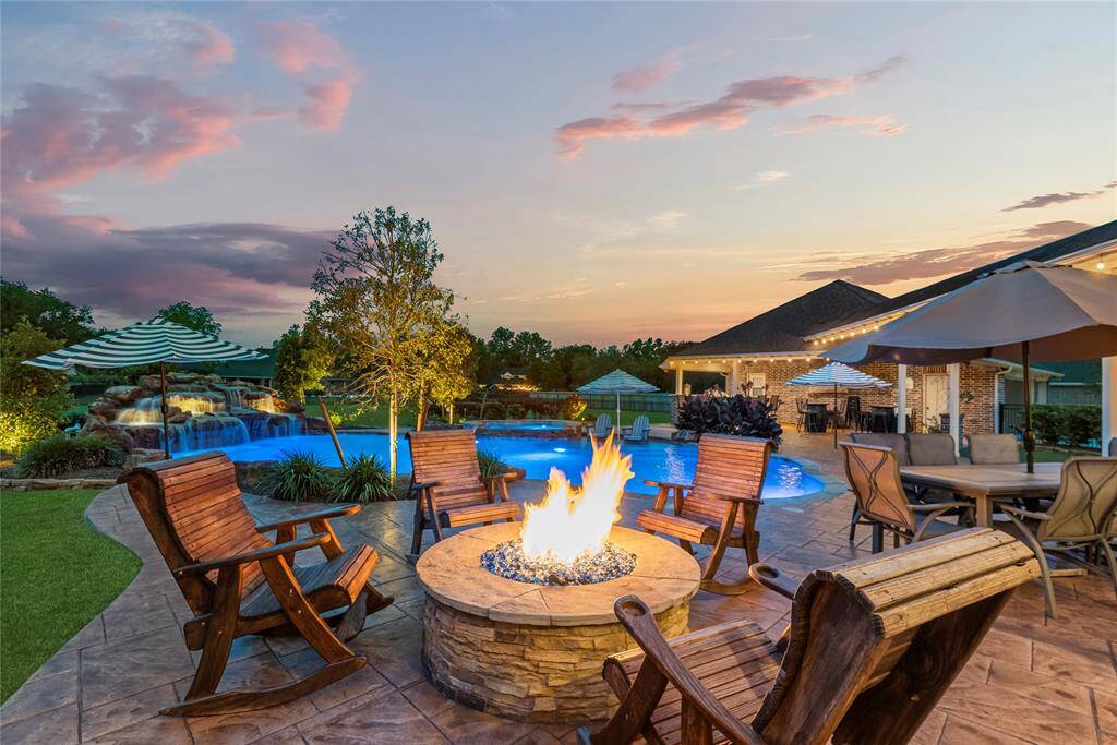 The custom-designed fire pit serves as a captivating focal point, radiating warmth and ambiance, offering a luxurious outdoor experience perfect for intimate gatherings or starlit evenings.