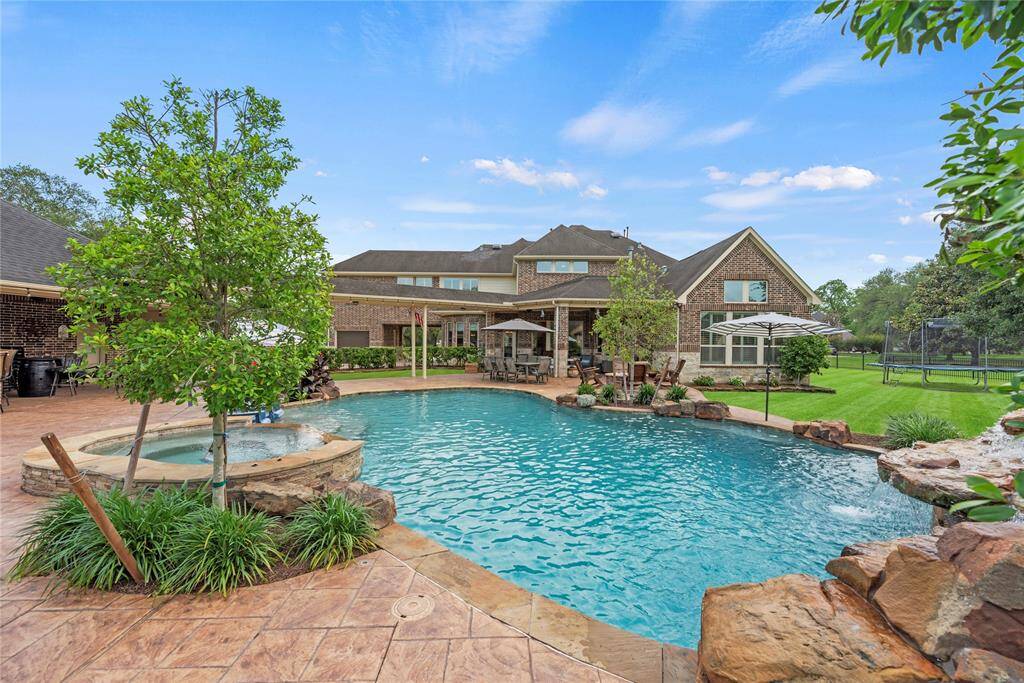 This backyard is a true paradise, where the shimmering blue waters of the pool reflect the endless blue skies above, creating a breathtaking outdoor sanctuary perfect for relaxation.