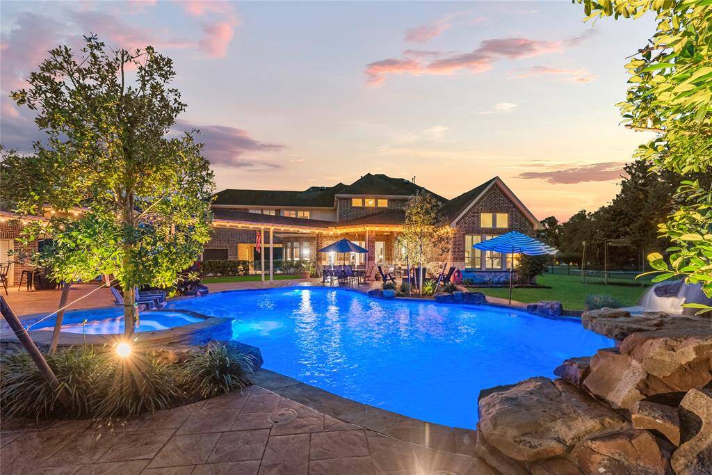 As night falls, the illuminated pool and meticulously designed backyard oasis transform into a tranquil sanctuary, evoking an entirely new level of ambiance and understated elegance.