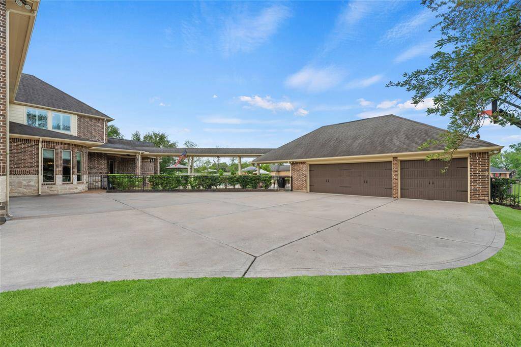 The expansive four-car garage, paired with a wide double driveway, offers exceptional convenience and ample space for multiple vehicles.