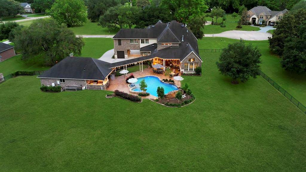 This breathtaking aerial view from the rear of the home captures the full scope of the property’s exceptional offerings, showcasing its expansive layout and meticulously designed outdoor spaces in one stunning panorama.