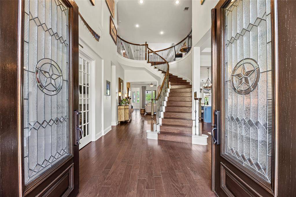 Step through stately double leaded-glass doors into a grand foyer adorned with rich engineered wood flooring and a beautifully crafted curved staircase, setting the tone for refined luxury throughout.