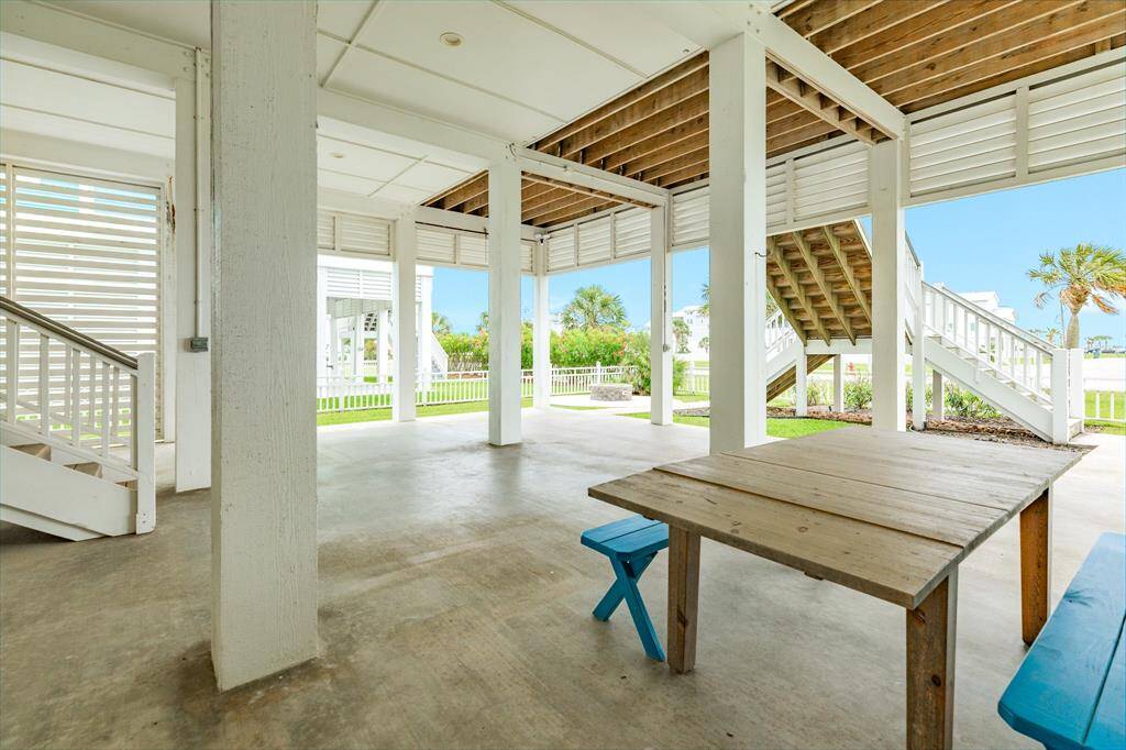 Feel the Gulf breeze while relaxing near your manicured lawn. It offers a bright, airy feel with views of a grassy yard and palm trees, making it ideal for outdoor gatherings or relaxation.