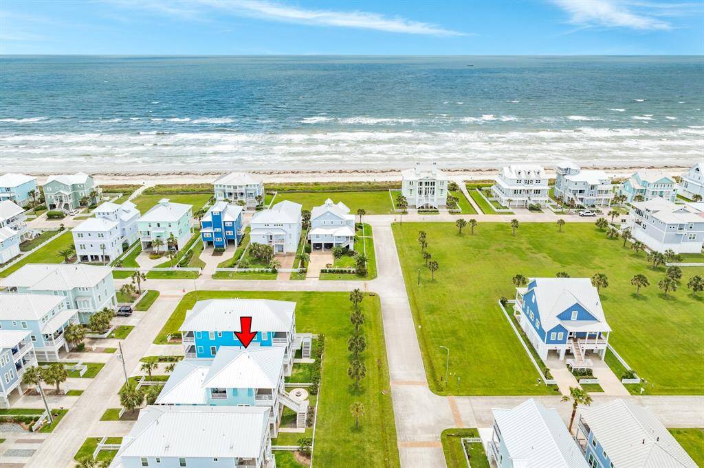 View the vibrant Beachside Village community with colorful beach houses, spacious green lawns, and direct access to the oceanfront. The highlighted home is just a short walk from the sandy beach, offering picturesque ocean views and a serene living environment. Perfect for beach lovers seeking a tranquil retreat.