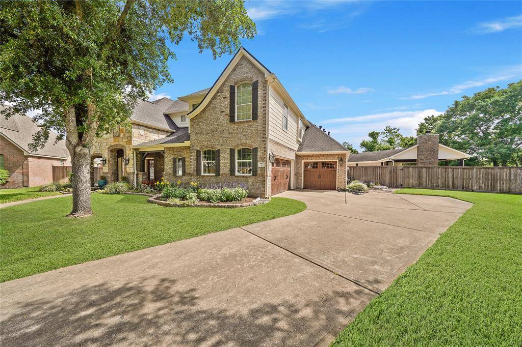 This charming two-story home features a brick and stone exterior with a spacious driveway leading to a two-car garage. The well-maintained lawn and mature trees add curb appeal, while the fenced backyard offers privacy. Ideal for families seeking comfort and style.