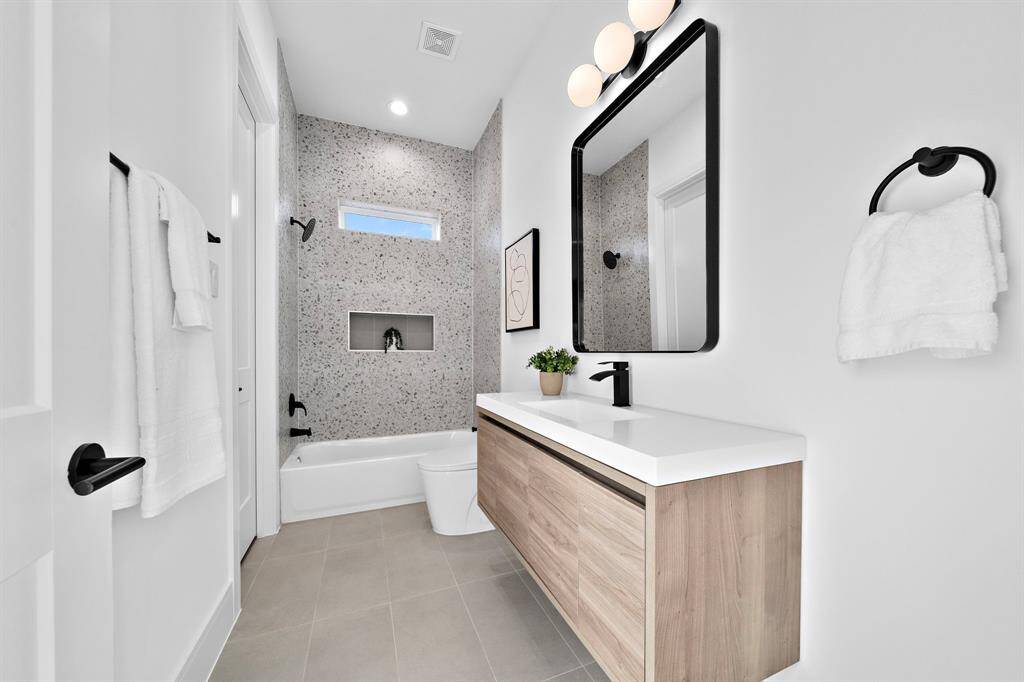 Connecting the two guest bedrooms is a convenient and beautifully designed Jack-and-Jill bathroom, offering shared access with private functionality and thoughtful design.