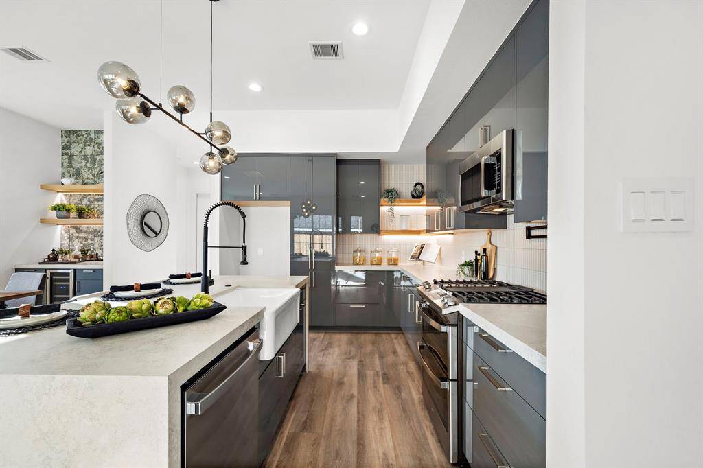 This kitchen is equipped with a high-performance 5-burner gas cooktop and stylish floating shelves accentuated by sleek LED underlighting, combining functionality with modern elegance.