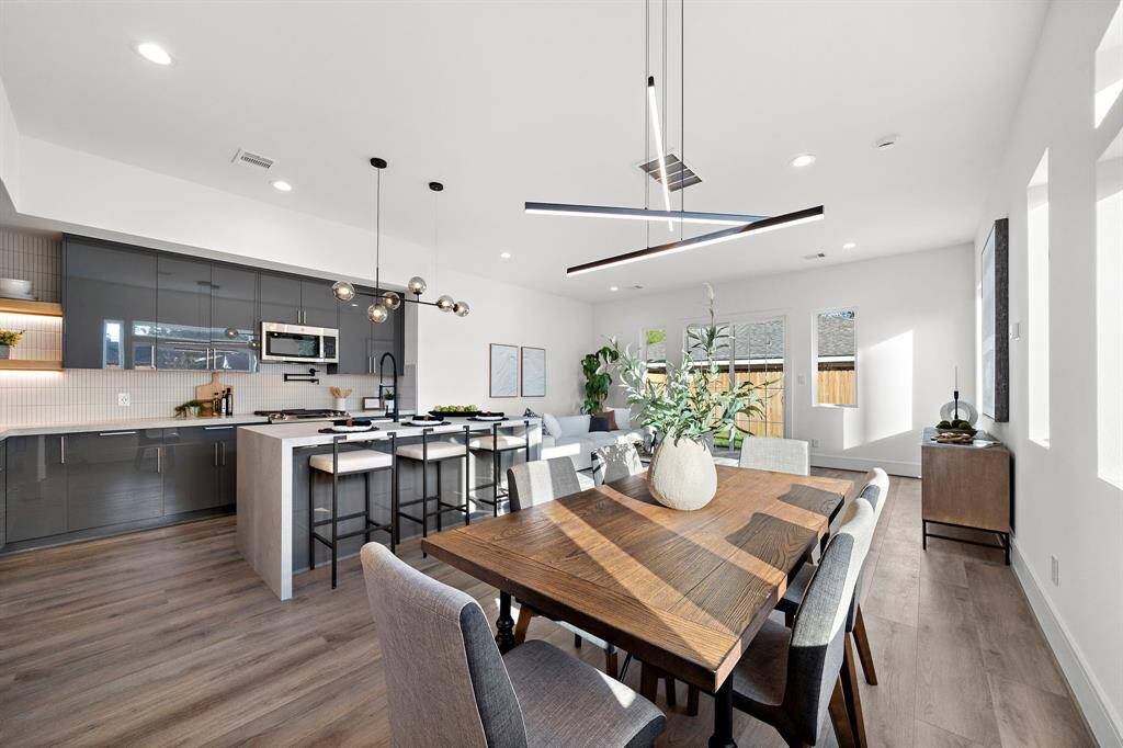 The dining room showcases a chic, modern chandelier and offers ample space to comfortably accommodate seating for 6-8 guests—perfect for hosting gatherings.