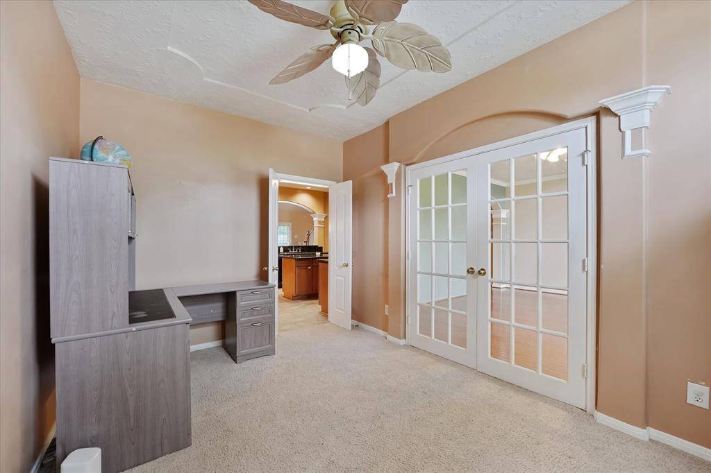 Office is well lit and has door to the kitchen.