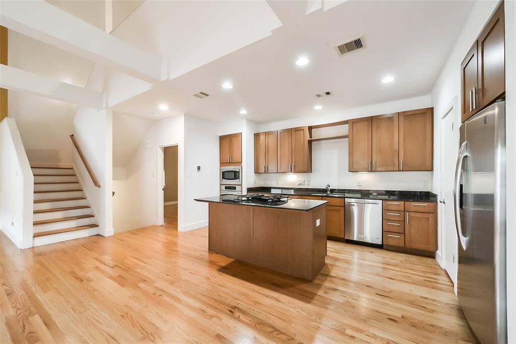 Spacious chef-inspired kitchen featuring granite counter tops, stainless steel appliances, and custom built in storage. Open concept views into the living and outdoor spaces.