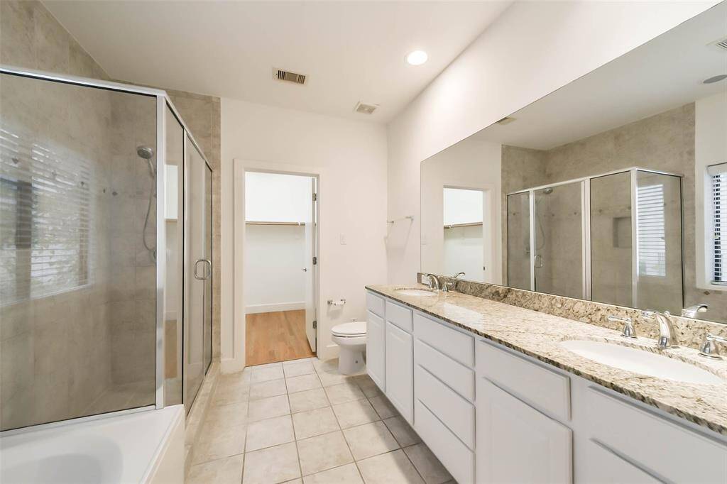 Primary bathroom en-suite with abundant counter space, storage, and natural light