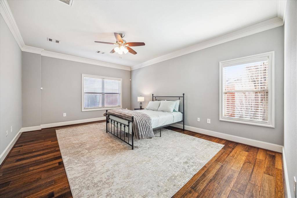 LARGE, FIRST FLOOR PRIMARY BEDROOM HAS AMPLE NATURAL LIGHT, HARDWOOD FLOORS, AND EXPANSIVE SPACES WITH PLENTY OF ROOM FOR A SITTING AREA.
