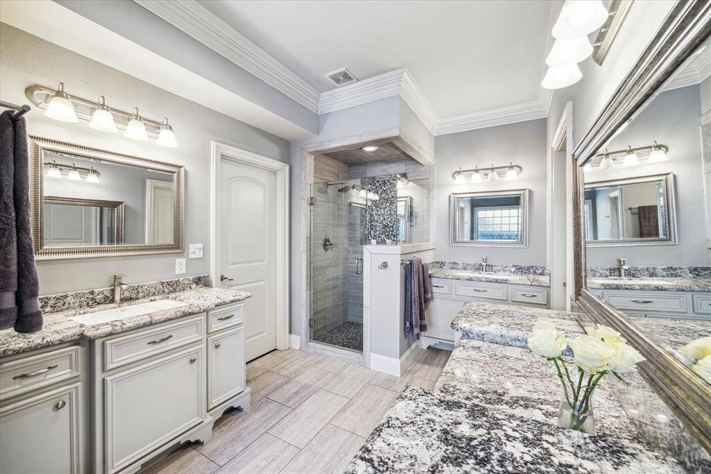 SPACIOUS PRIMARY BATH FEATURES TWO VANITIES, A PRIVATE WATER CLOSET, A SEPARATE SHOWER AND STAND ALONE BATHTUB.
