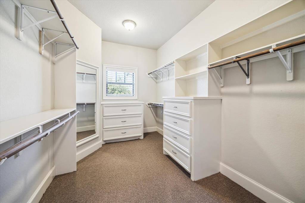 WALK IN CLOSET WITH A VIEW OF THE FRONT YARD.