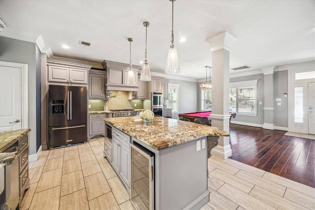 KITCHEN FEATURES HIGH-END STAINLESS STEEL APPLIANCES, INCLUDING BEVERAGE REFRIGERATOR.