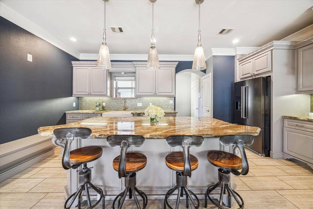 JUST BEYOND THE KITCHEN, YOU WILL FIND A LARGE PANTRY, UTILITY ROOM AND ACCESS TO THE BACK PATIO.
