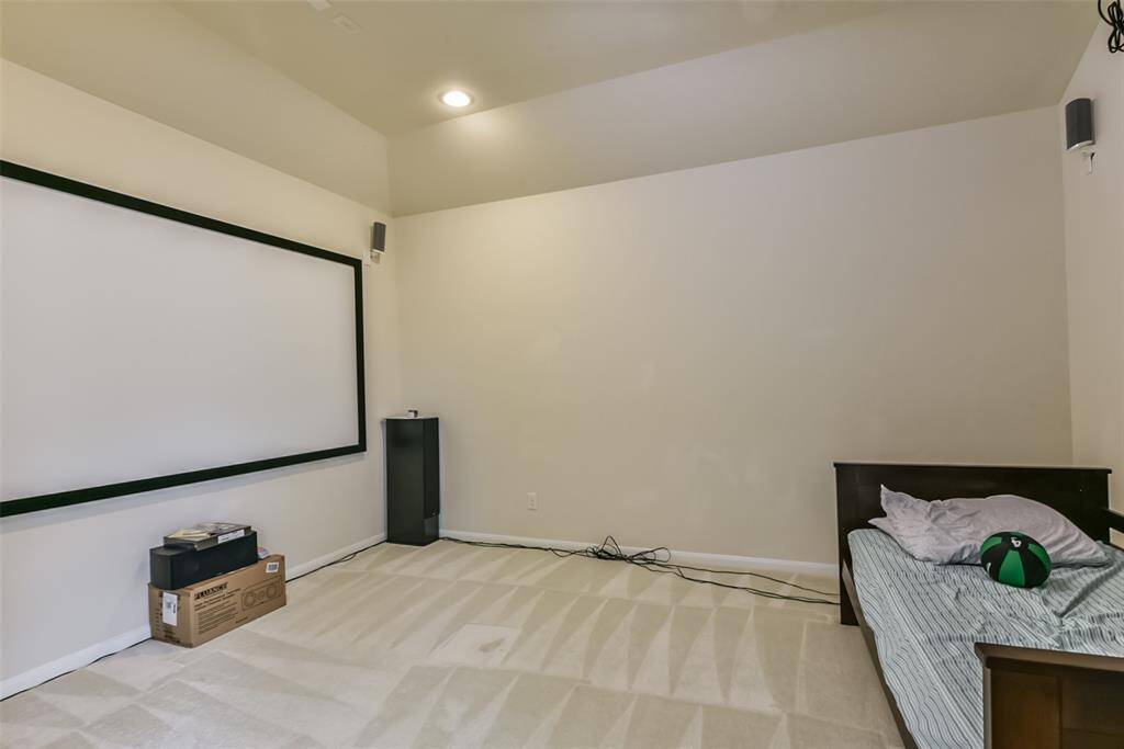 The media room features plush carpet, high ceilings, and recessed lighting.