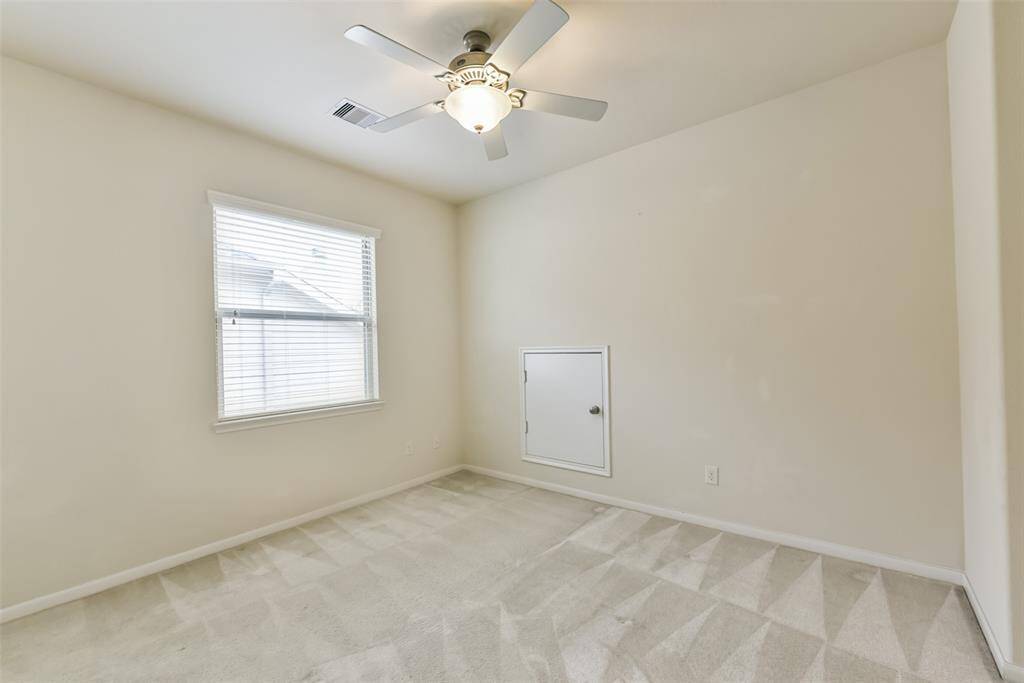Fourth bedroom features awindow and plush carpet.