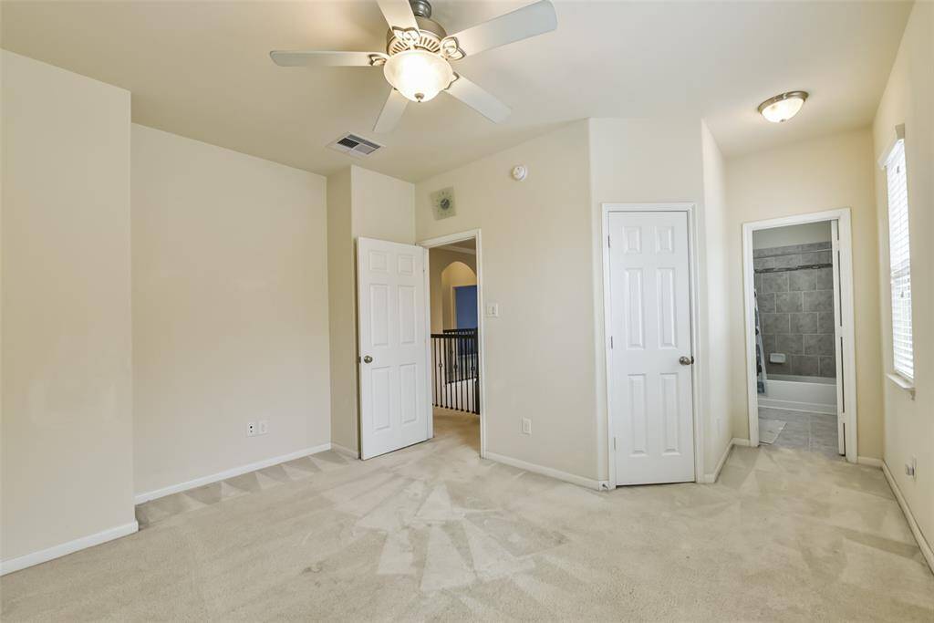 Fourth bedroom features awindow and plush carpet.