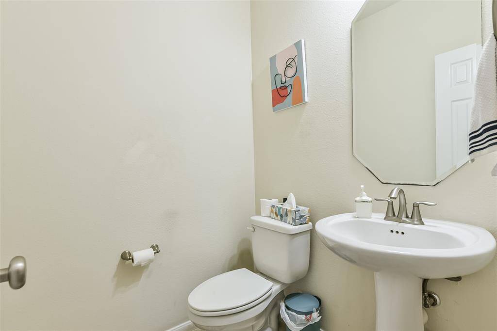 The half bathroom features a modern pedestal sink.