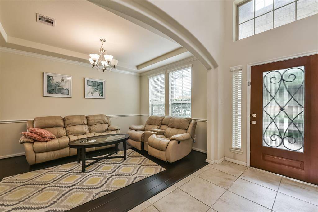 The welcoming den features a chair rail, beautiful floors, and large windows.