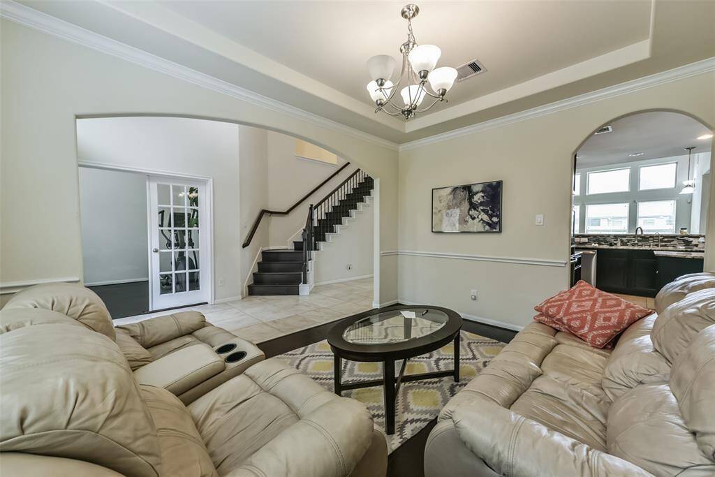 The welcoming den features a chair rail, beautiful floors, and large windows.