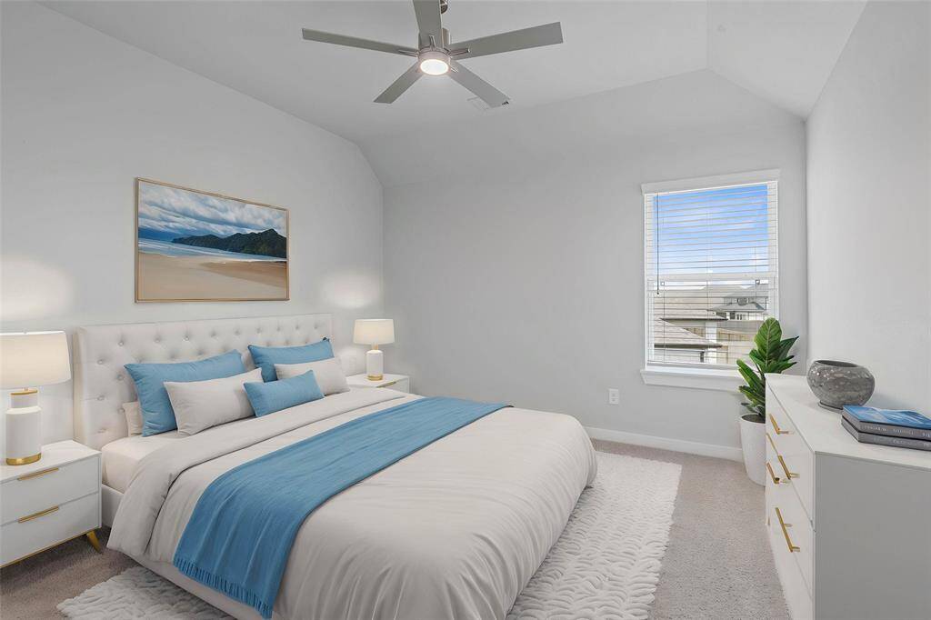 Secondary bedroom features plush carpet, custom paint, ceiling fan with lighting, closet space, and a large window with privacy blinds.