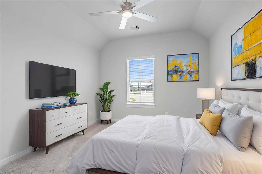 Secondary bedroom features plush carpet, custom paint, ceiling fan with lighting, closet space, and a large window with privacy blinds.