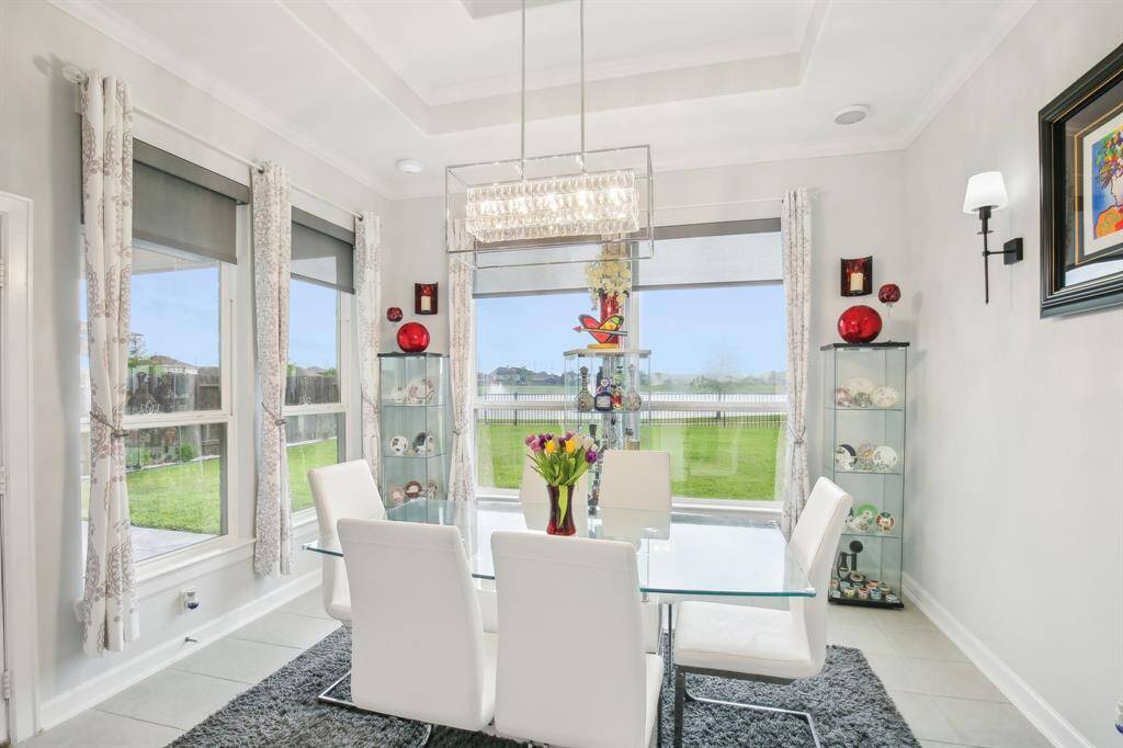 This bright dining room features large windows showcasing a scenic backyard view - perfect for enjoying meals with a view!
