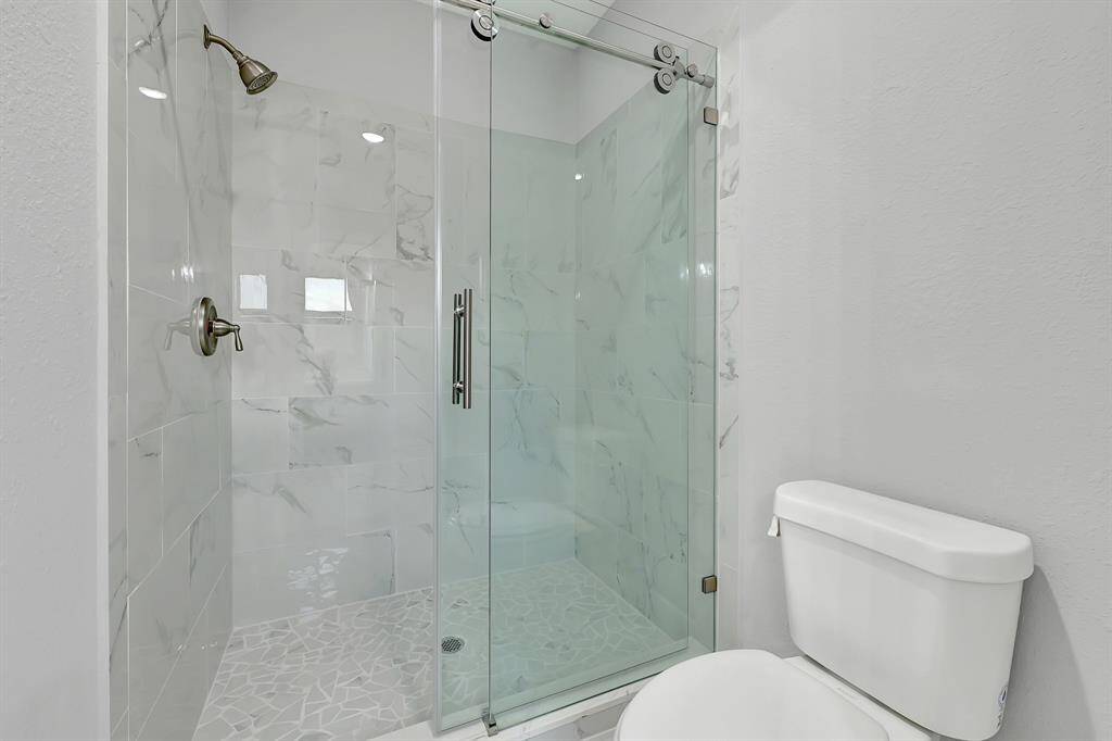 jack and hill bathroom with shower and frameless shower door.