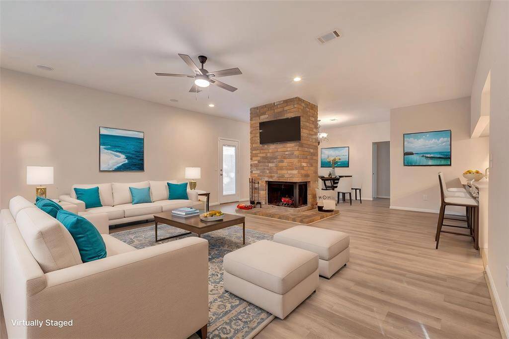 Virtually staged living area featuring a cozy fireplace, perfectly situated between the formal dining room and main living space.