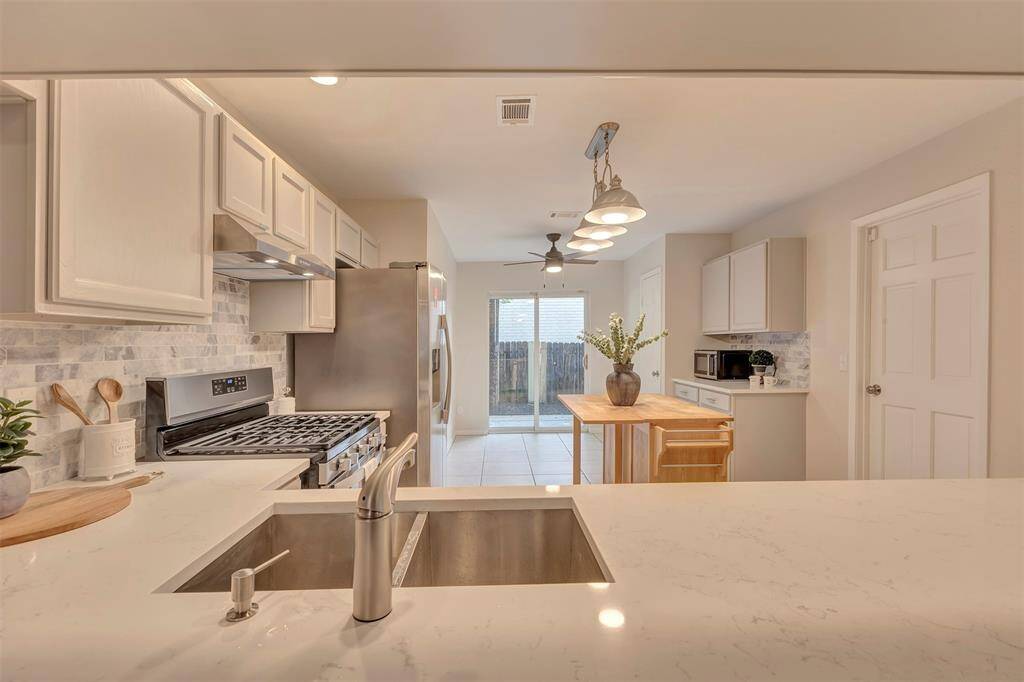 Updated kitchen with modern countertops and stylish backsplash.