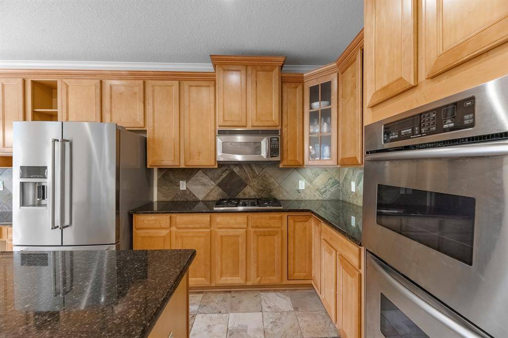 The kitchen offers plenty of cabinet space, a double oven, and gas cooktop