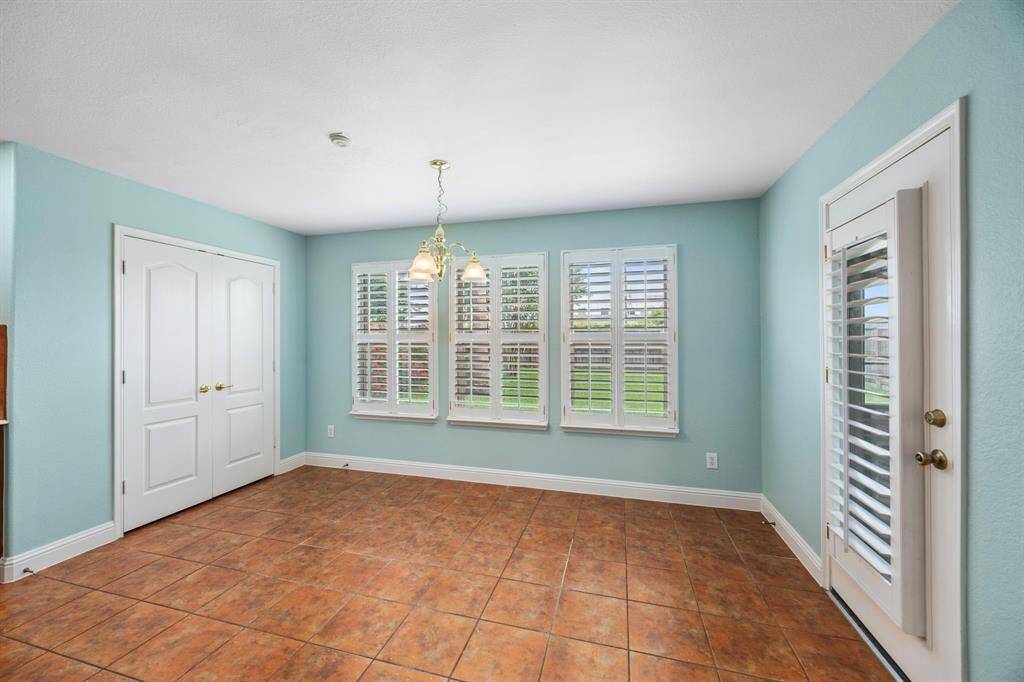 Dining room with plantation shutters that open to the backyard.