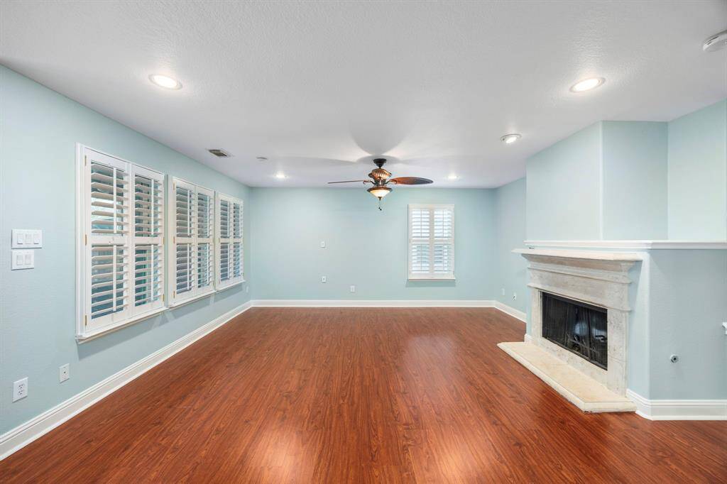 The living room with plantation shutters that open to the back, and the cozy fireplace for gathering.