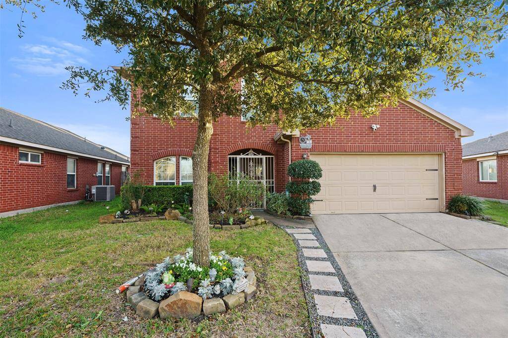 Charming red-brick home with a two-car garage and well-maintained landscaping. Features a welcoming pathway, mature tree, and manicured front yard. Ideal for comfortable family living.