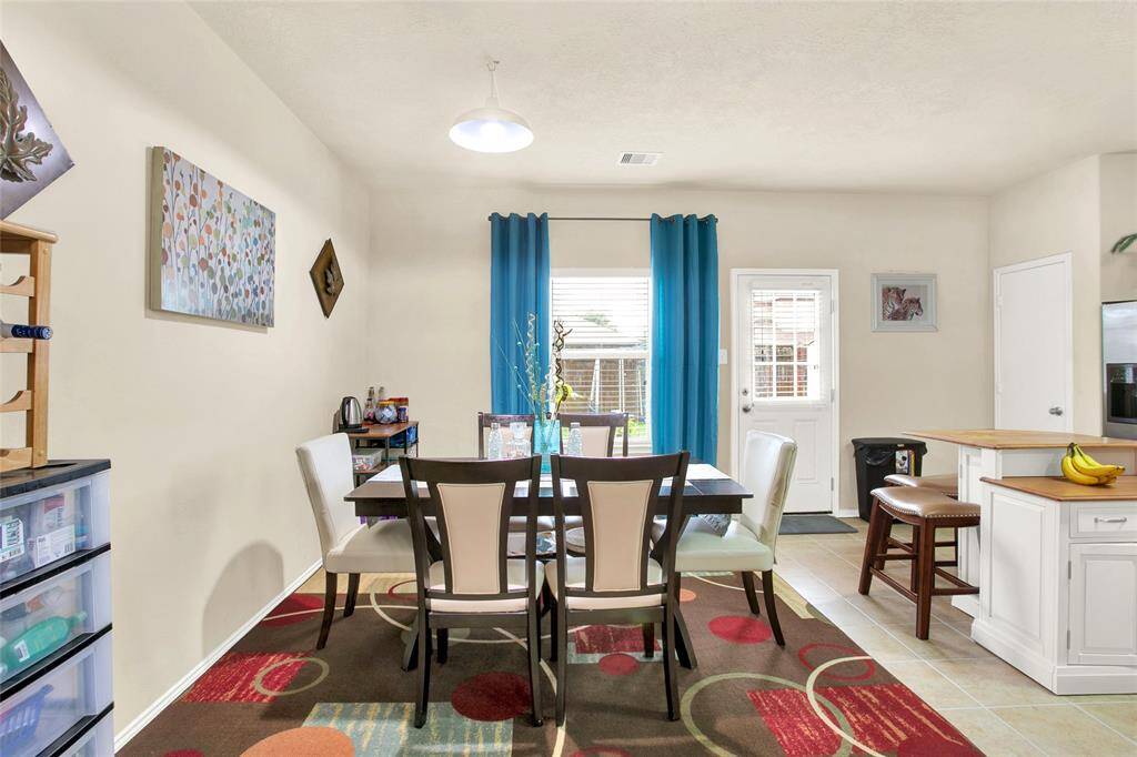 Step into the inviting warmth of this sunlit dining space, complete with a seamless flow to the charming outdoor area through glass sliding doors. The open-plan design includes a convenient kitchen with a breakfast bar perfect for casual dining.