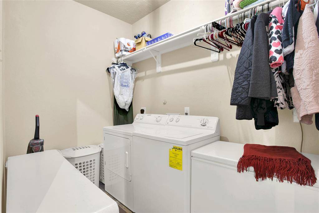 Efficient laundry area with modern appliances, ample overhead storage, and convenient hanging space.