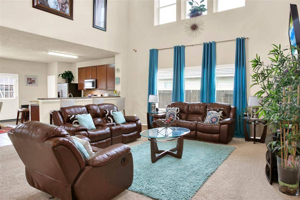 Discover the epitome of elegance in this airy living space boasting soaring ceilings and a flood of natural light, seamlessly transitioning into a modern kitchen for effortless entertaining.