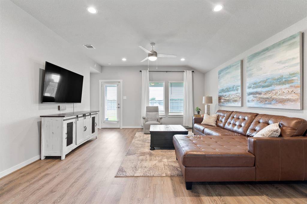 The family room features canned lighting, large windows that fill the space with natural light, and direct access to the backyard, creating a bright, open atmosphere ideal for relaxing or entertaining.