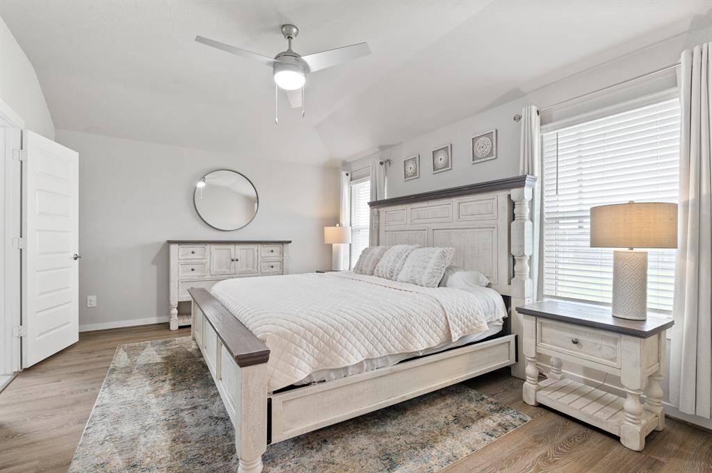 The spacious primary suite boasts large windows that invite in natural light, creating a serene retreat. It includes a private en suite bathroom for added comfort and convenience.