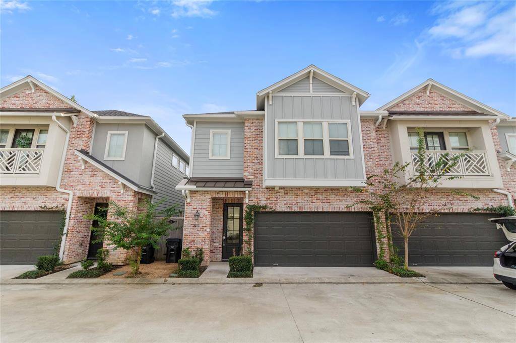 Modern two-story townhouse with brick and siding exterior. Features a two-car garage and a small front garden area. The architecture is contemporary, situated in a neat, well-maintained neighborhood.